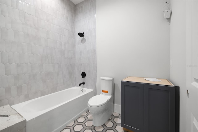 bathroom featuring toilet and tiled shower / bath