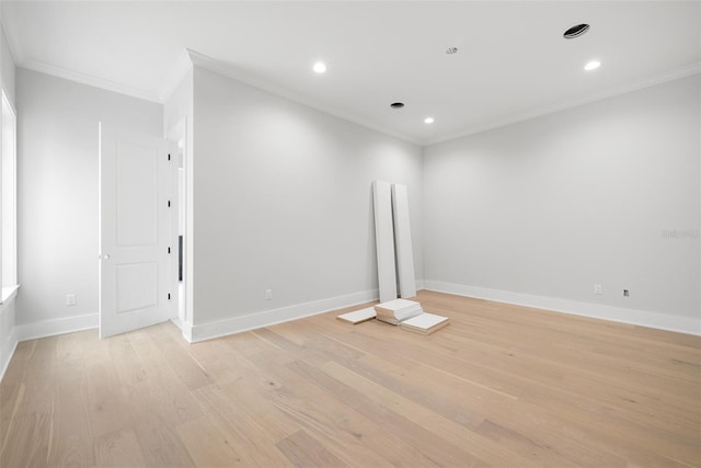 spare room featuring ornamental molding and light hardwood / wood-style flooring