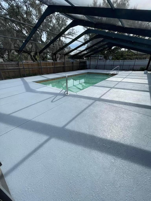 view of swimming pool with a patio and glass enclosure