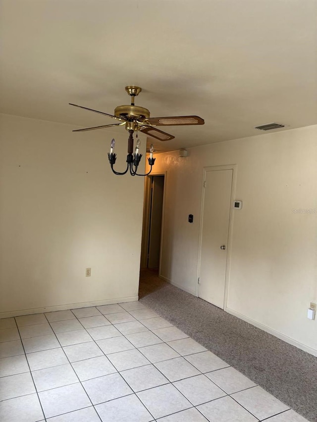 empty room featuring ceiling fan with notable chandelier