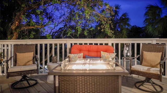 deck at night featuring a fire pit