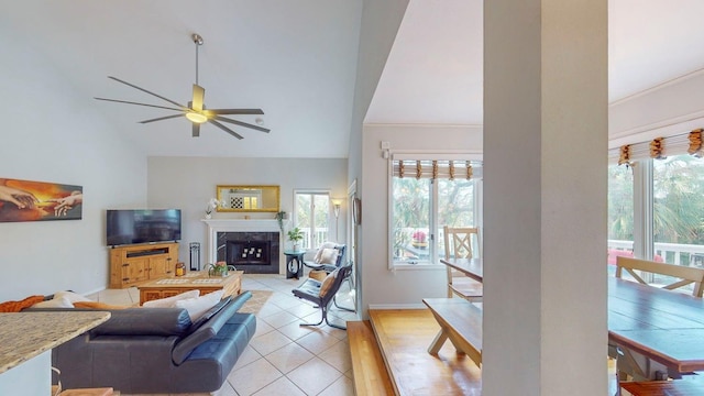 tiled living room with a fireplace, high vaulted ceiling, a wealth of natural light, and ceiling fan