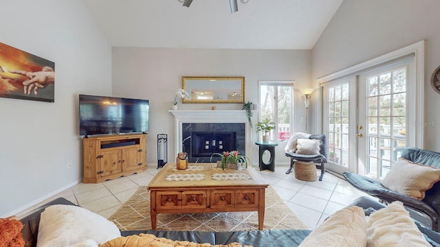 living room featuring a fireplace, light tile patterned floors, high vaulted ceiling, and french doors