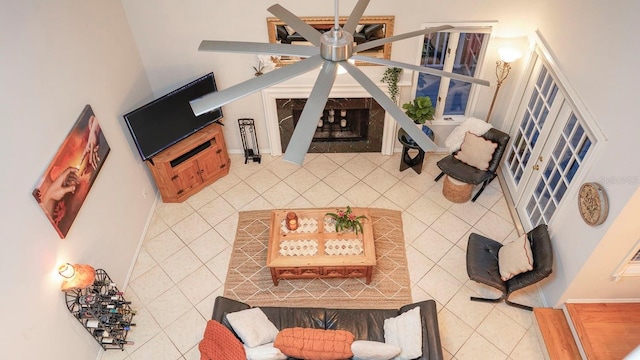 tiled living room with ceiling fan and a fireplace