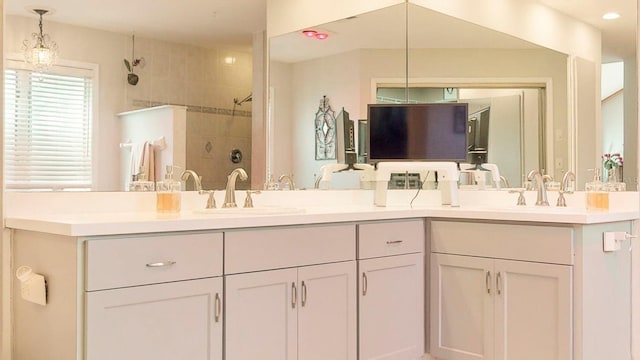 bathroom featuring a tile shower and vanity