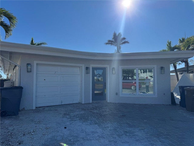 view of front of home with a garage, decorative driveway, and stucco siding