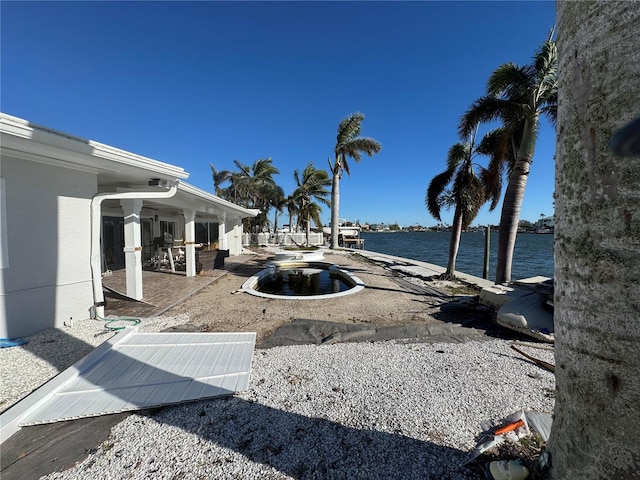 view of yard featuring a water view, a patio, and a pool