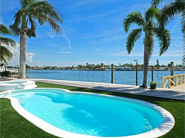 view of swimming pool featuring a pool with connected hot tub and a water view