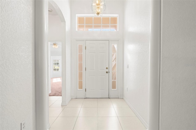 tiled entryway with an inviting chandelier