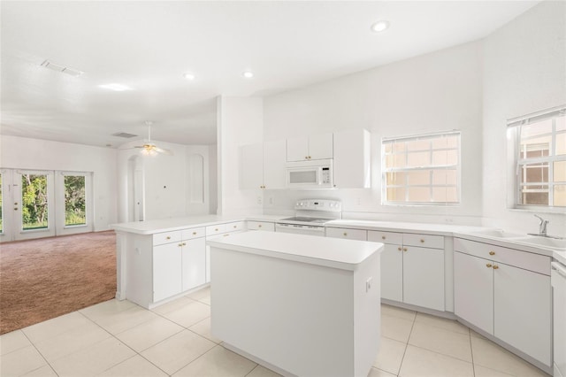 kitchen with a center island, sink, white appliances, and a healthy amount of sunlight