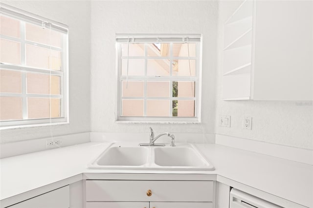 kitchen featuring white cabinets and sink