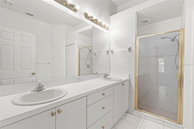 bathroom with vanity, tile patterned floors, and a shower with door