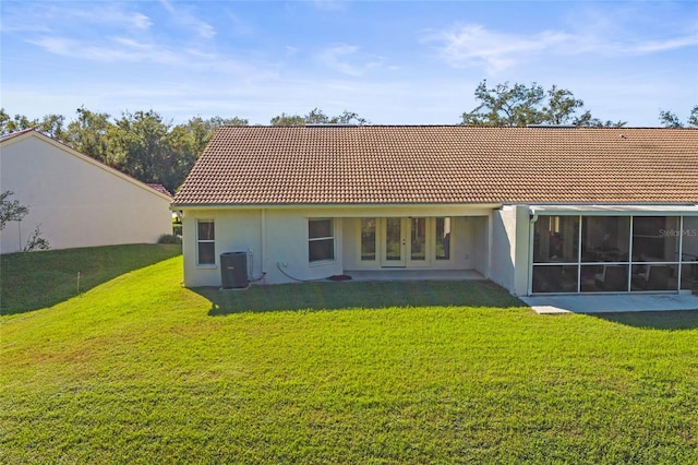 back of property with a lawn and central air condition unit