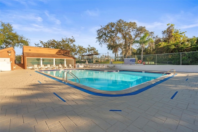 view of swimming pool featuring an outbuilding and a patio area