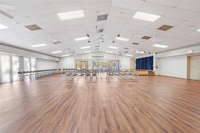 workout area with ceiling fan, a drop ceiling, and wood-type flooring