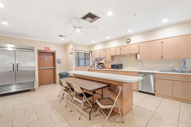 kitchen featuring ceiling fan, sink, light tile patterned floors, a kitchen island, and appliances with stainless steel finishes