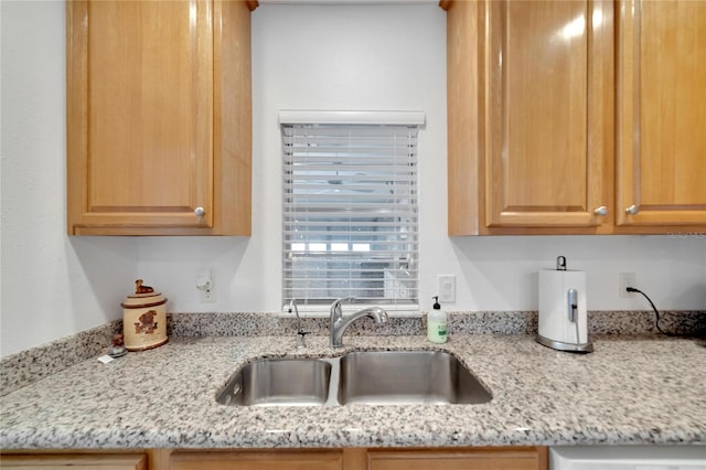 kitchen with light stone counters and sink