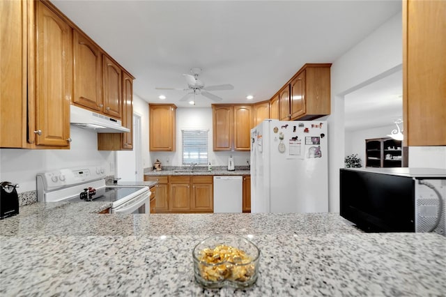 kitchen featuring light stone counters, sink, ceiling fan, and white appliances