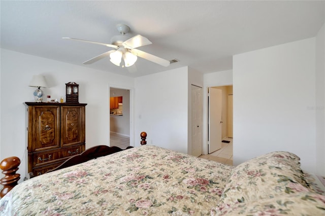 tiled bedroom with ceiling fan and a closet