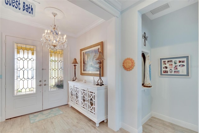 foyer featuring hardwood / wood-style flooring, french doors, a chandelier, and ornamental molding