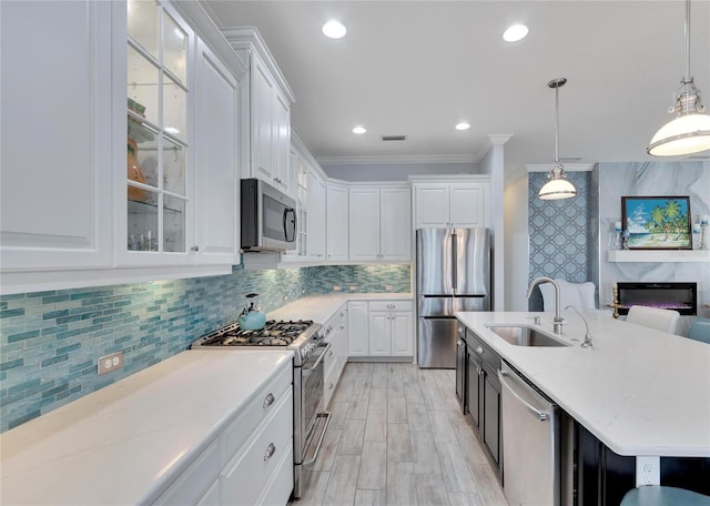 721 Manns Harbor Dr, Apollo Beach, FL 33572 - kitchen with stainless steel appliances, a sink, white cabinets, ornamental molding, and glass insert cabinets