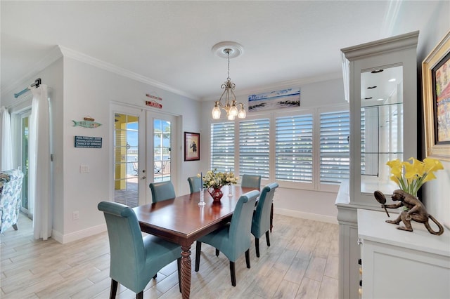 dining room with light wood-type flooring, crown molding, and french doors