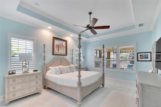 bedroom featuring light carpet, a tray ceiling, ceiling fan, and crown molding