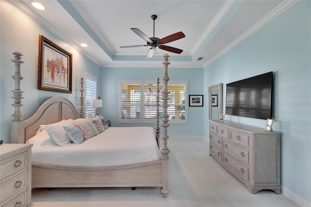 bedroom with a tray ceiling, multiple windows, ornamental molding, and ceiling fan