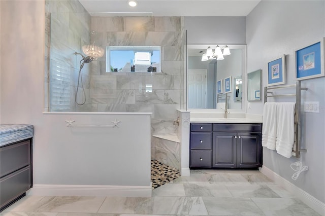 bathroom featuring tiled shower, vanity, and a notable chandelier