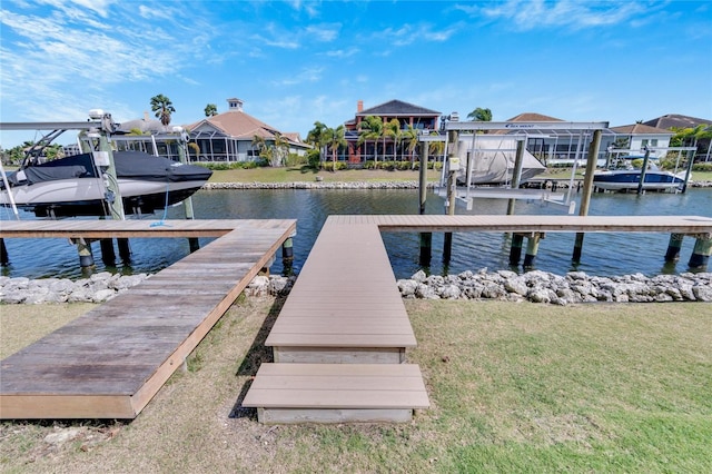 view of dock featuring a lawn and a water view