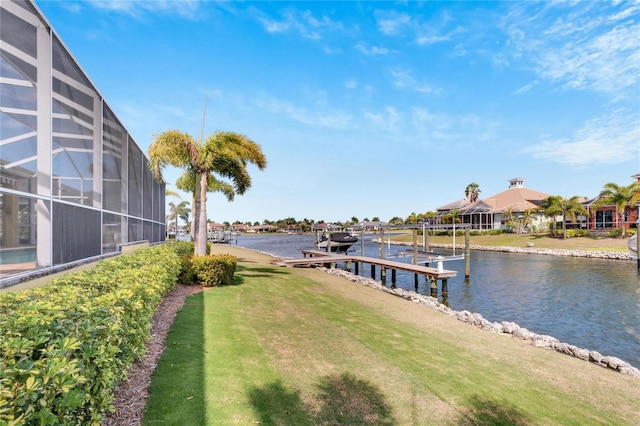 dock area featuring a lanai, a yard, and a water view