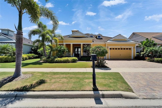 721 Manns Harbor Dr, Apollo Beach, FL 33572 - view of front of house featuring a front lawn, a garage, and decorative driveway