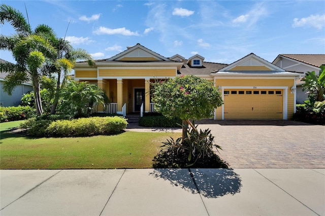 721 Manns Harbor Dr, Apollo Beach, FL 33572 - view of front of home featuring covered porch, decorative driveway, a front lawn, and an attached garage