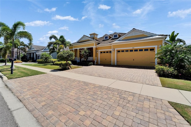721 Manns Harbor Dr, Apollo Beach, FL 33572 - view of front facade with decorative driveway, an attached garage, and a front lawn