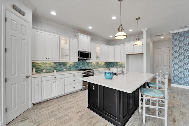 721 Manns Harbor Dr, Apollo Beach, FL 33572 - kitchen with appliances with stainless steel finishes, light countertops, white cabinetry, crown molding, and glass insert cabinets