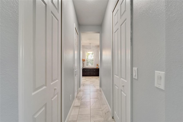 721 Manns Harbor Dr, Apollo Beach, FL 33572 - hallway featuring light marble finish flooring and a textured wall