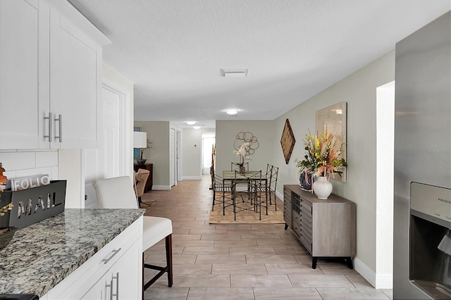 interior space featuring white cabinets, stone countertops, and light hardwood / wood-style flooring