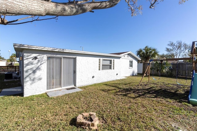 back of house with a yard and a playground