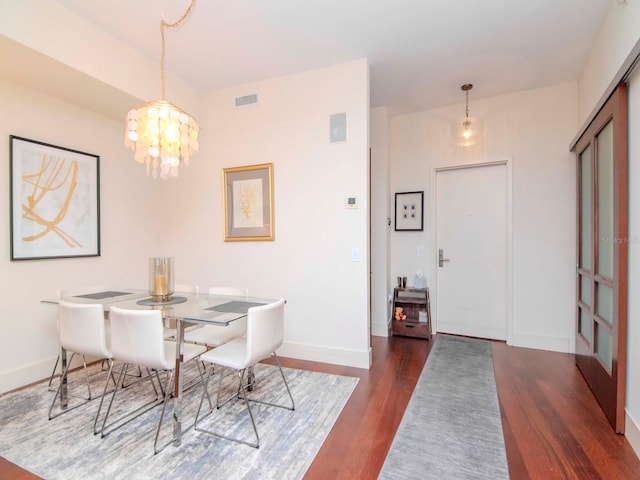 dining space with a chandelier and dark wood-type flooring