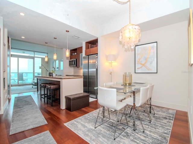 dining area with dark hardwood / wood-style flooring and an inviting chandelier