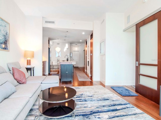 living room with light hardwood / wood-style flooring and sink