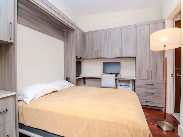 bedroom featuring hardwood / wood-style flooring and built in desk