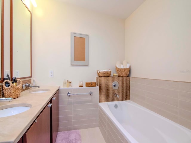 bathroom with tile patterned flooring, vanity, and a relaxing tiled tub