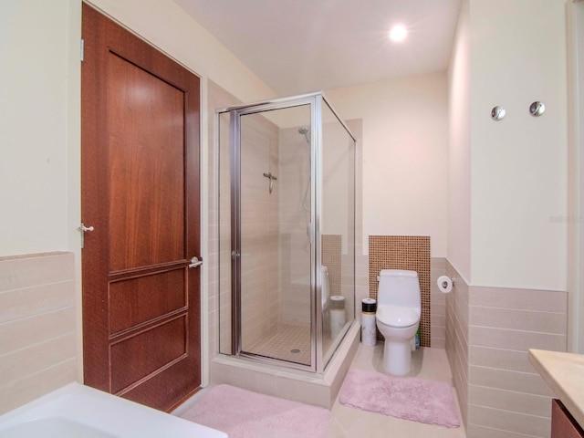 bathroom featuring an enclosed shower, vanity, toilet, and tile walls