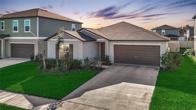 front of property with a lawn and a garage