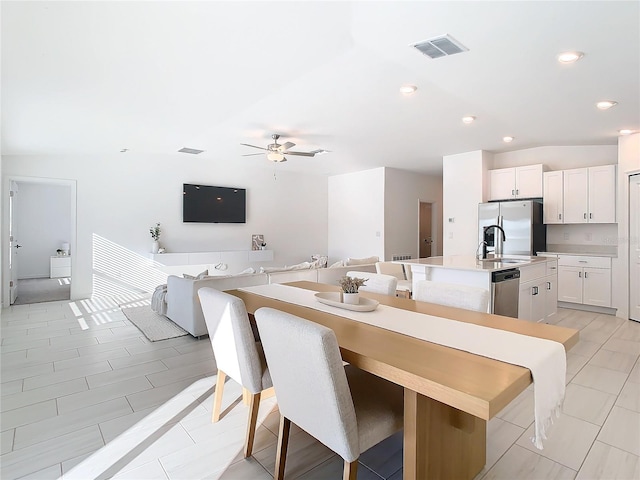 dining area with ceiling fan and sink