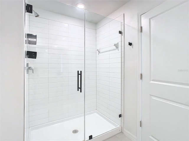 bathroom featuring a shower with door