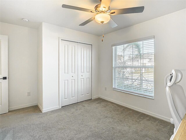 8849 Little Bluestem Dr, Land O Lakes, FL 34637 - unfurnished bedroom featuring light carpet, baseboards, a closet, and ceiling fan