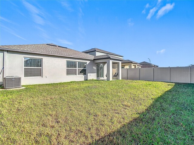 8849 Little Bluestem Dr, Land O Lakes, FL 34637 - rear view of property featuring cooling unit, stucco siding, and roof with shingles