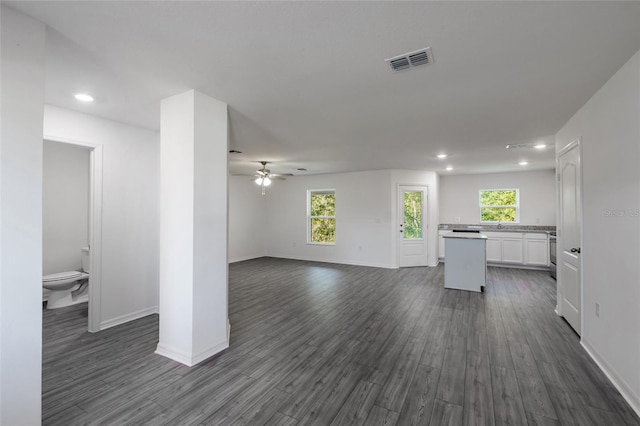 unfurnished living room featuring dark hardwood / wood-style floors and ceiling fan